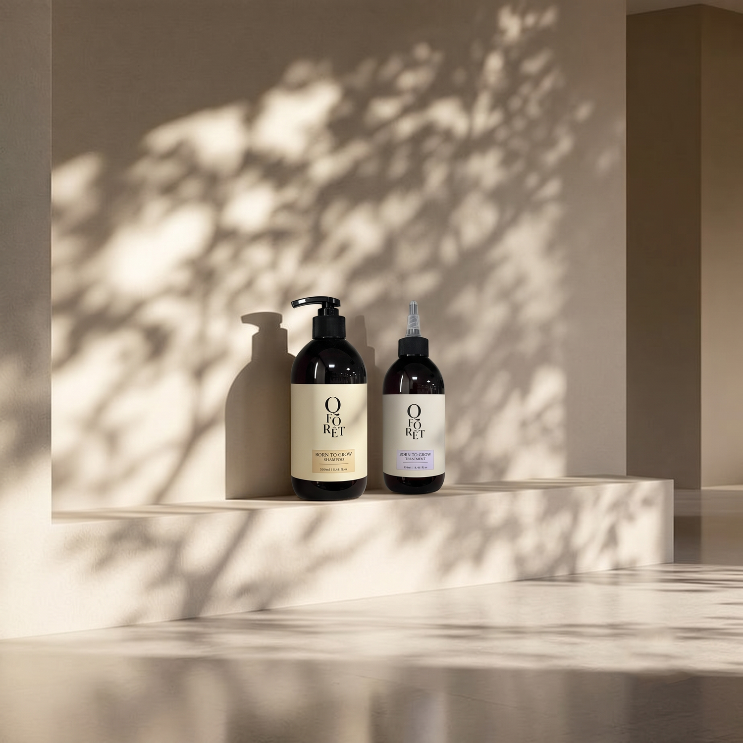 Two dark amber bottles from the brand 'QFORET' with cream-colored labels, standing on a minimalist beige platform with artistic leaf shadows cast across the background.